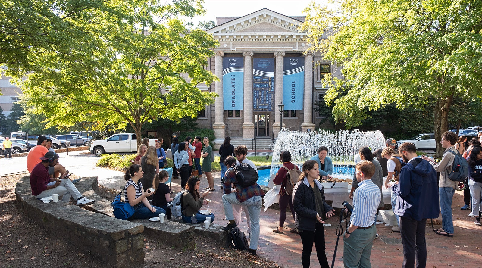 Group of UNC-Chapel Hill graduate students and faculty and staff gathered near the fountain outside of Bynum Hall during a get-together.
