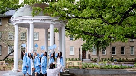 Graduates pose for photos by the Old Well
