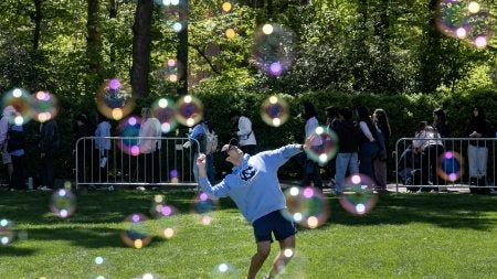 Bubles seen in the foreground as a UNC-Chapel Hill student is seen on a lawn throwing a ball.