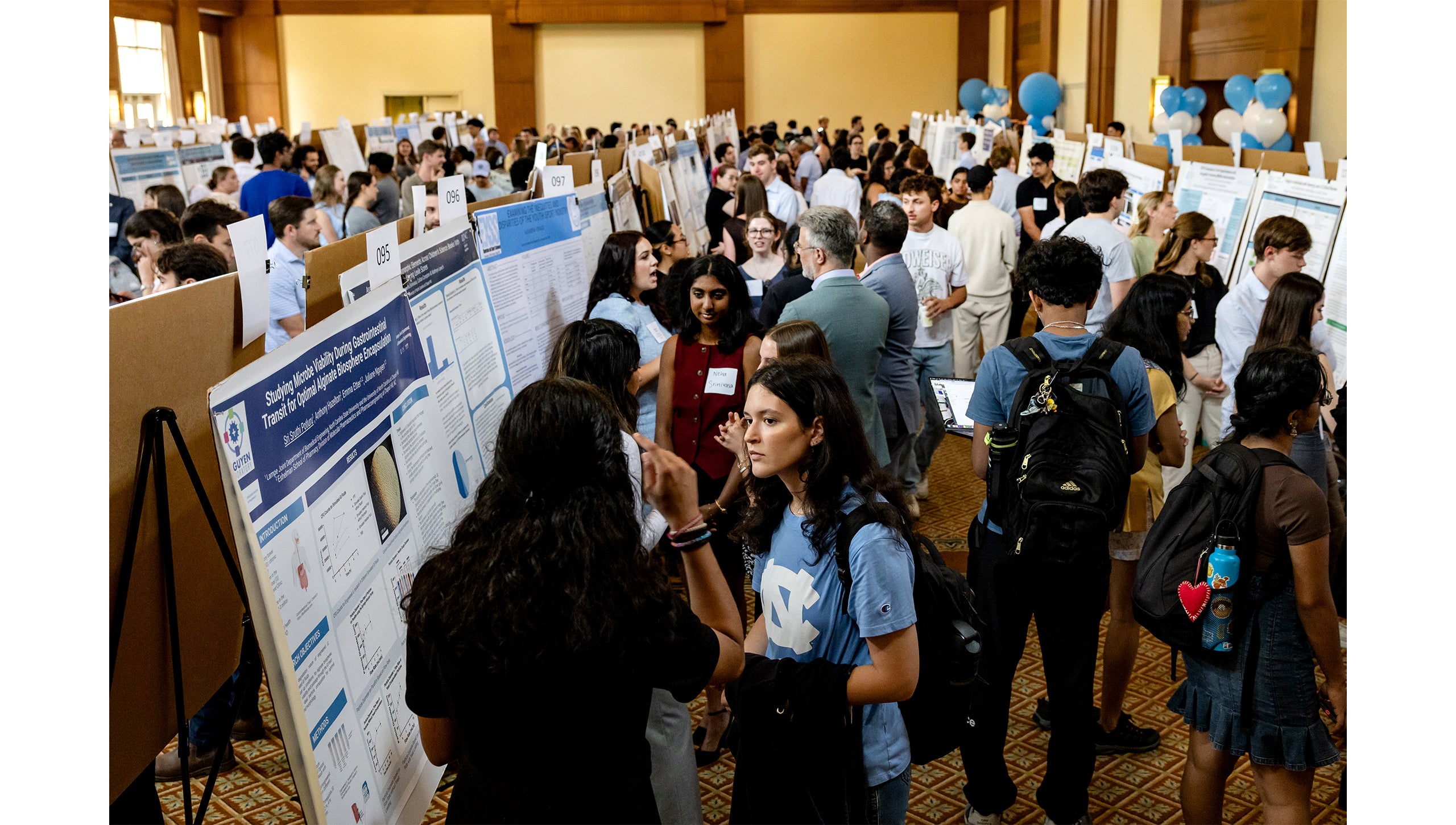 Attendees mingle by posters at the Celebration of Undergraduate Research