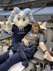 Katie Musgrove giving blood while getting a visit from RJ.