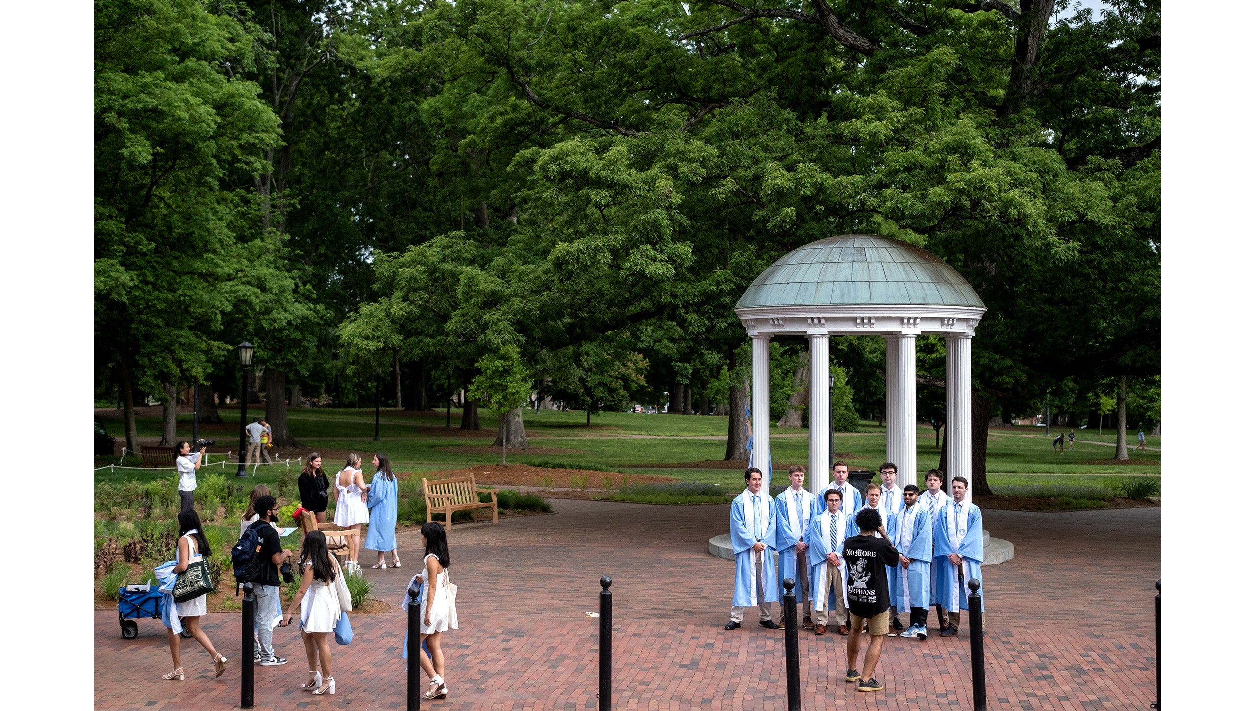 Graduates pose for photos by the Old Well