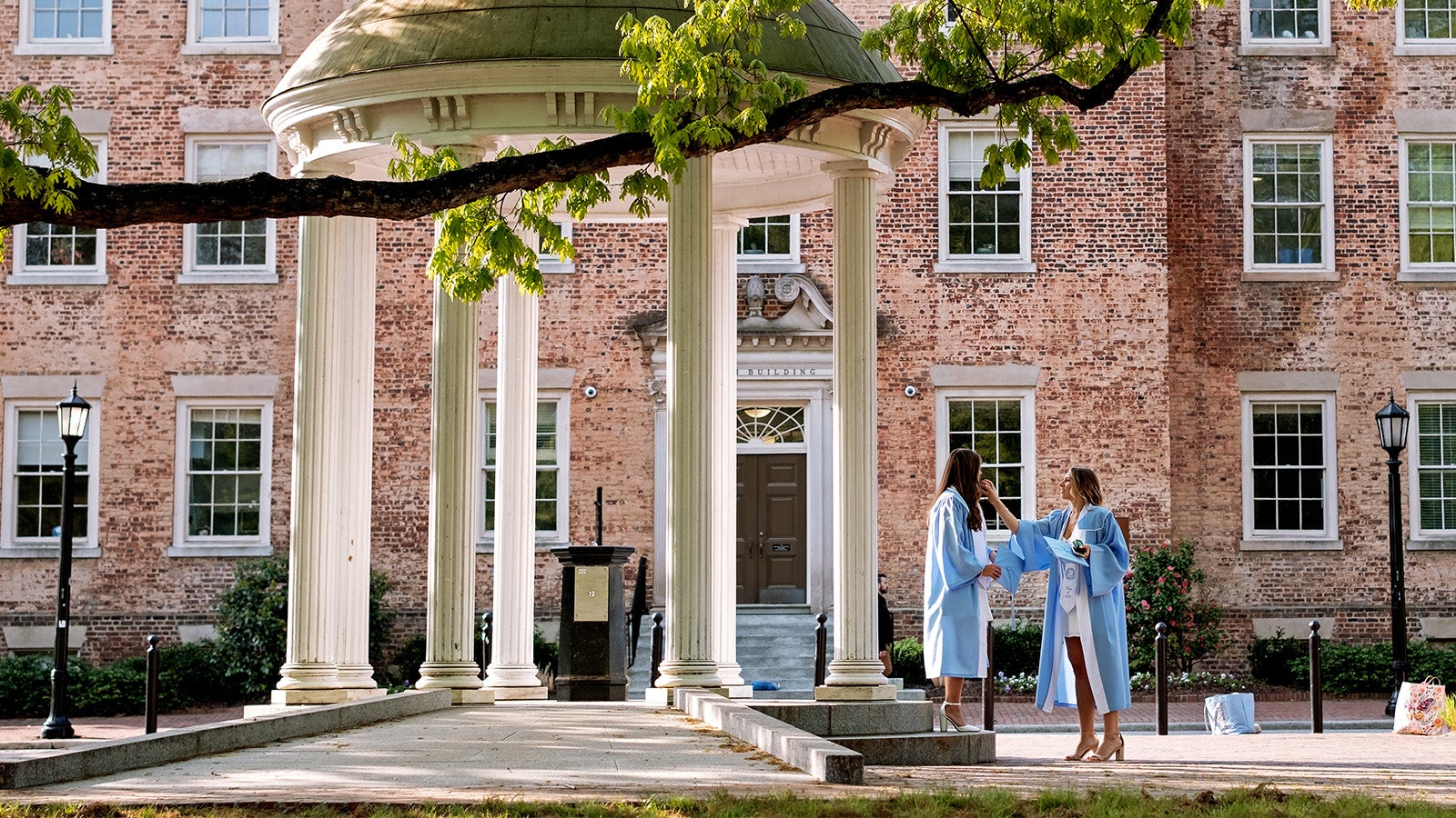 Graduates take photos by the Old Well