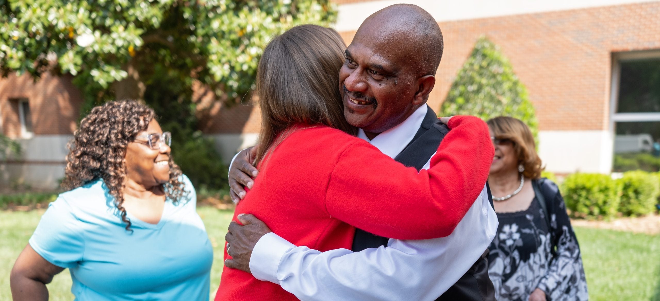 James Brower hugs a colleague as he gets recognized for his dedication to Carolina.