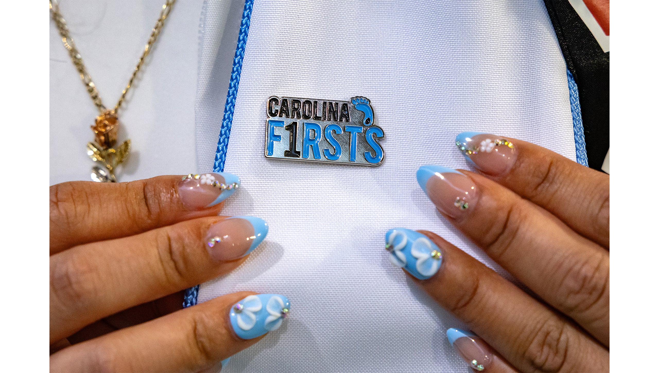 A graduate shows off their Carolina Firsts pin.