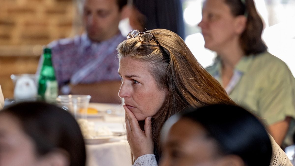 Kathleen Colville sitting down and intently listening to a speaker.