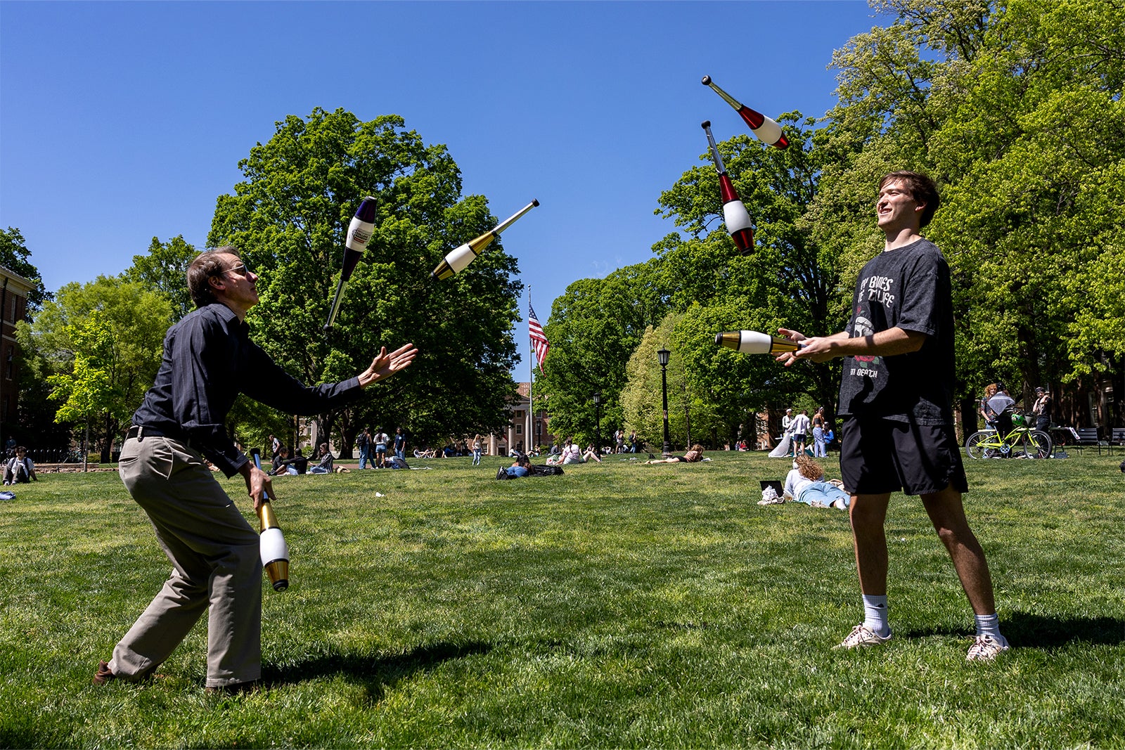 Members of the Juggling Club toss batons back and forth on Polk Place
