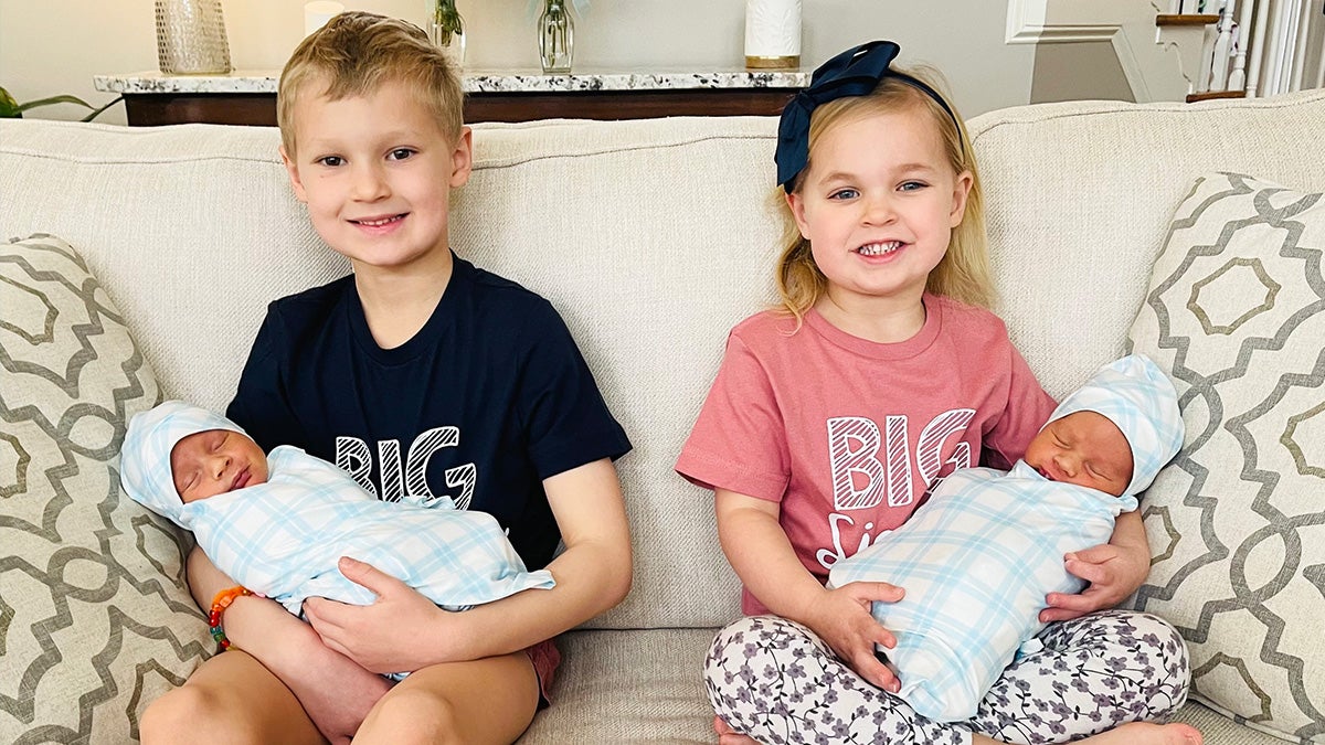 Two children holding baby siblings.
