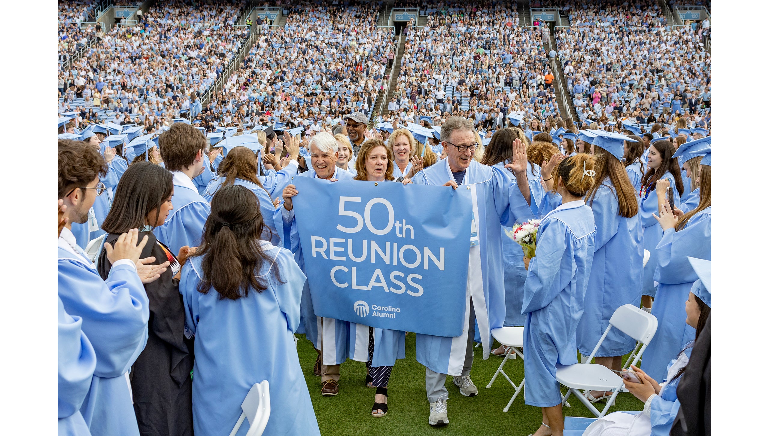 Members of the 50th reunion class walk through the crowd at Spring Commencement, high-fiving graduates.