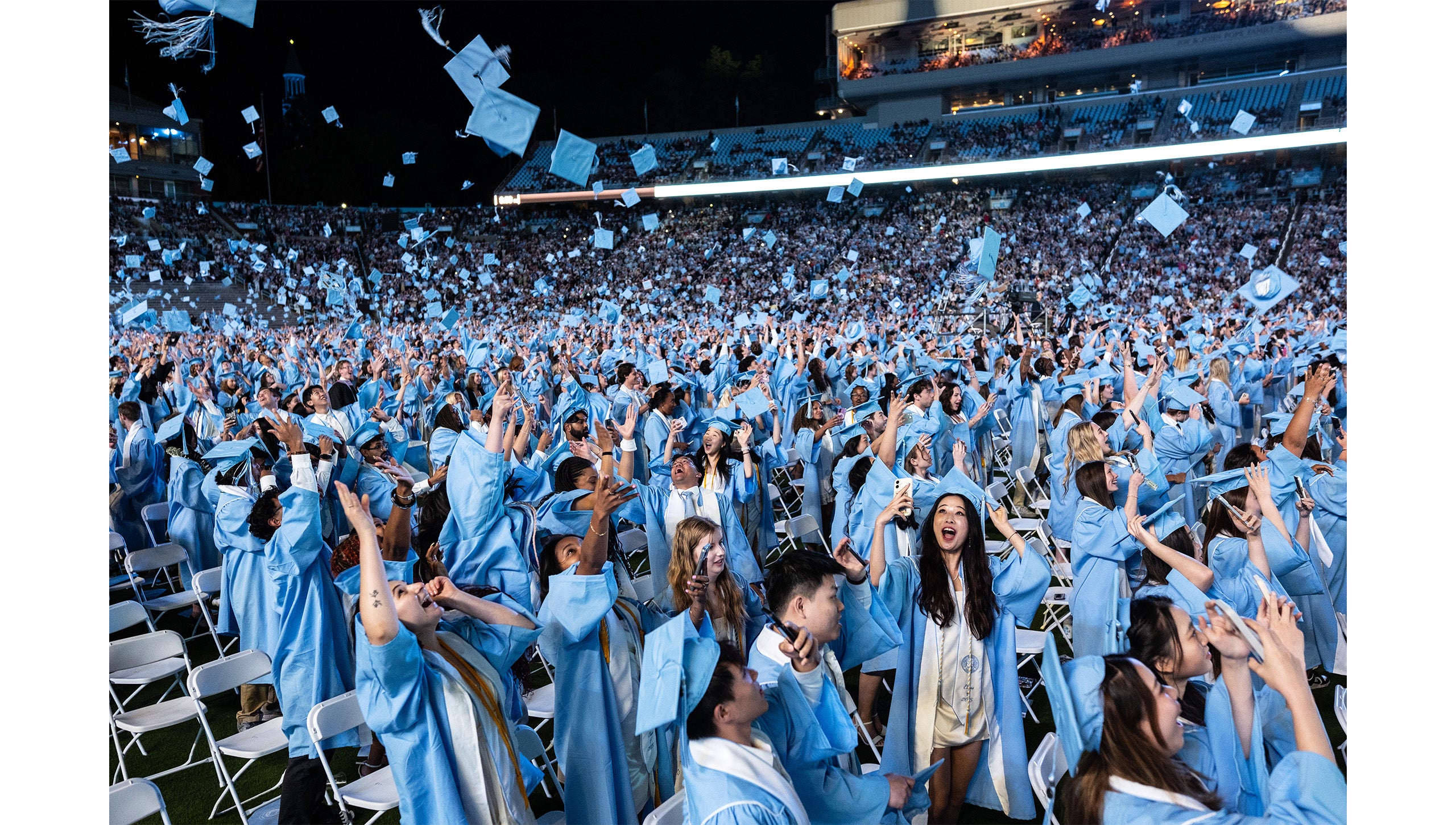 Graduates toss their caps in the air at the end of Carolina's 2025 Spring Commencement.