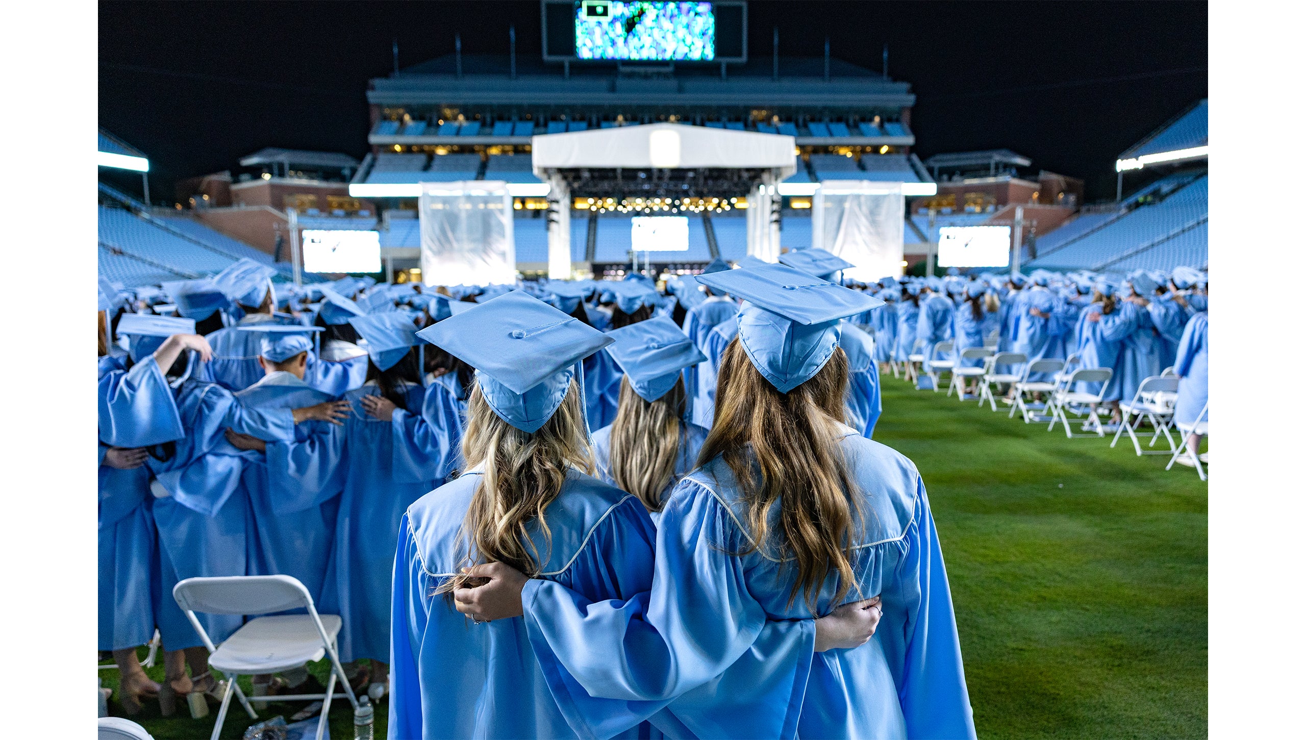 Graduates put arms around each other's backs at the end of Carolina's 2025 Spring Commencement.