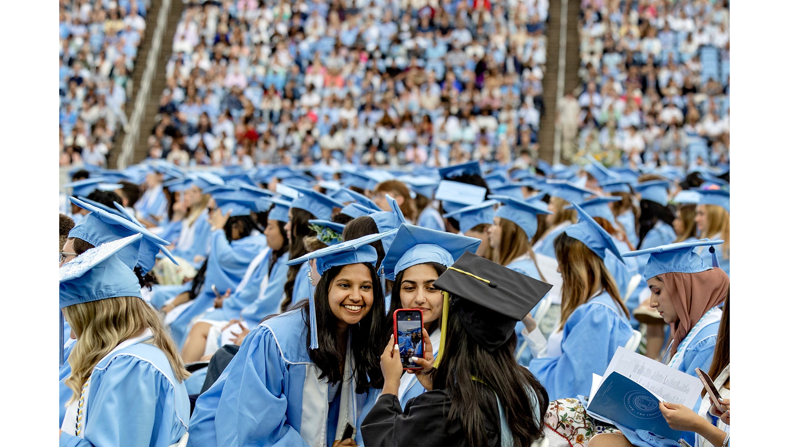 Graduates pose on the field before Spring Commencement.