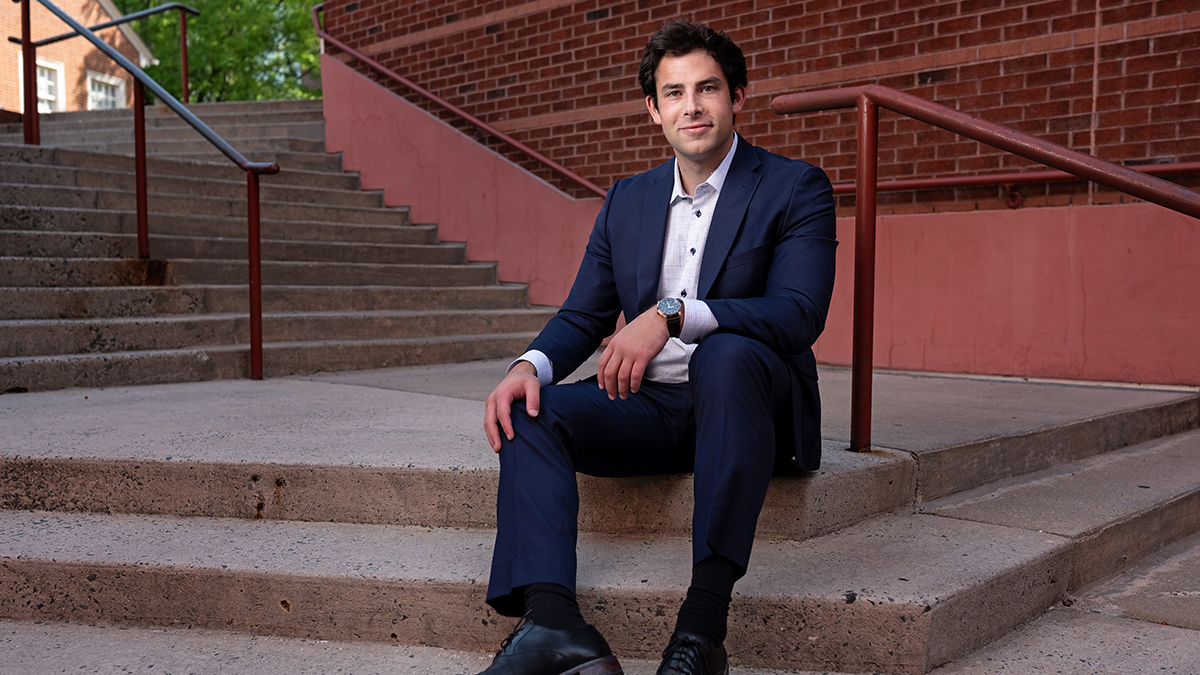 Benny Klein sitting on steps with suit on.