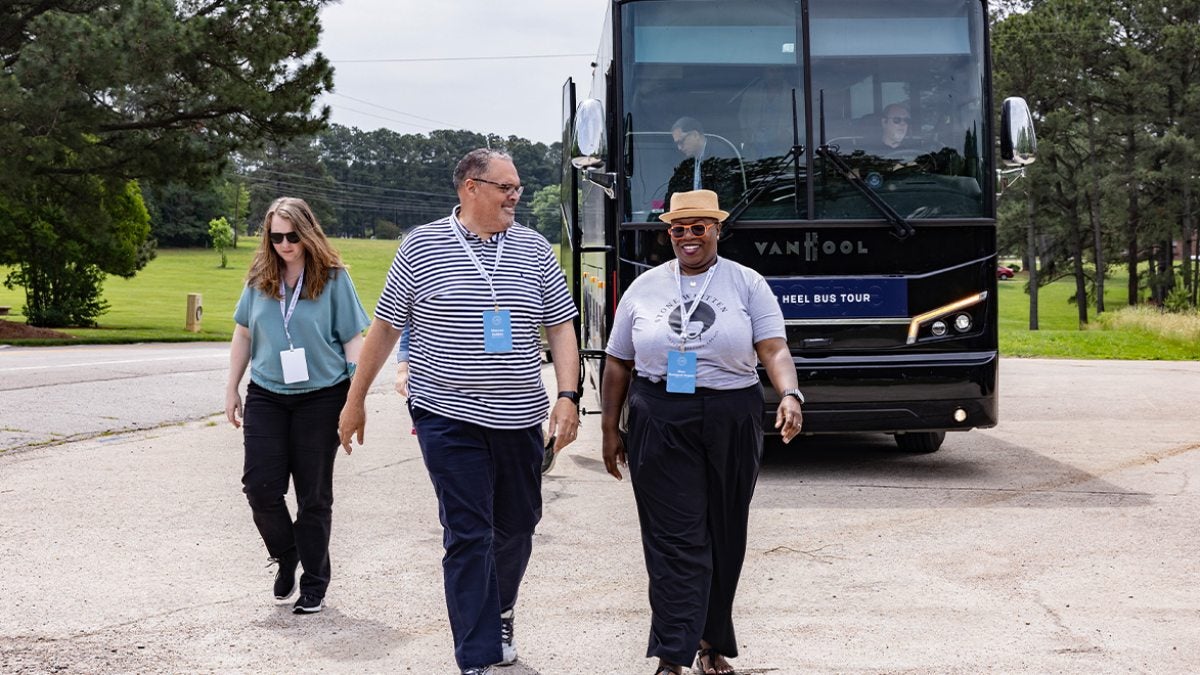 Rhon Manigault-Bryant and a fellow Tar Heel Bus Tour attendee walking outside near the bus.