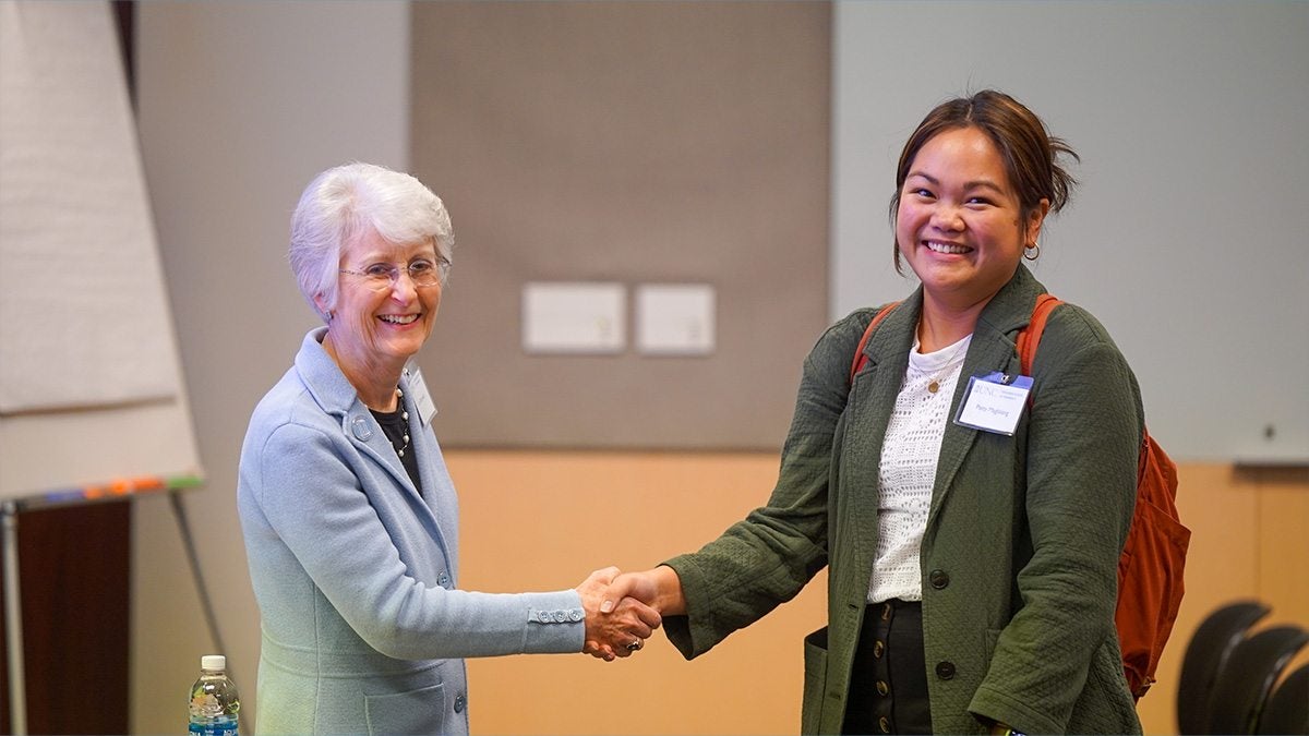 Kim Brouwer (left) and Patty Maglalang (right) shake hands at the UNC Pharmaceutical Sciences Research Retreat.