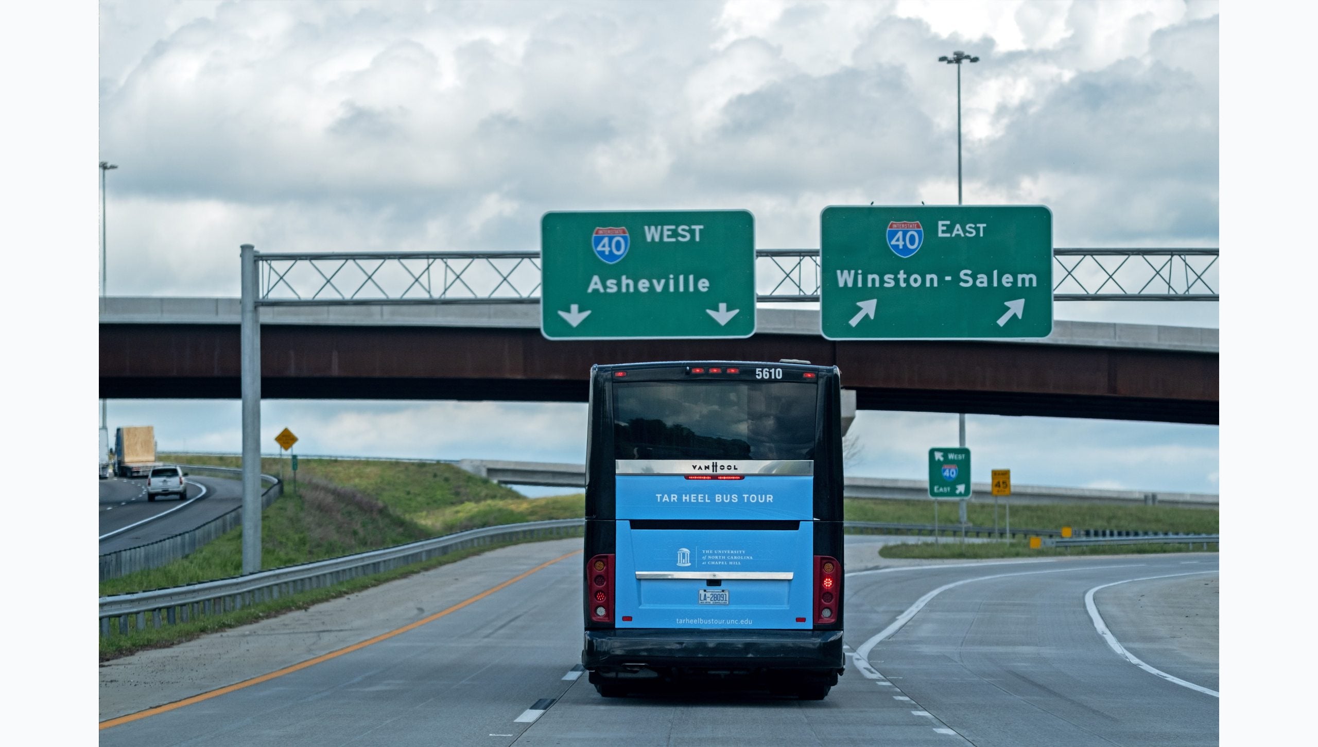 Tar Heel Bus Tour West bus on highway approaching signs for Asheville and Winston-Salem.