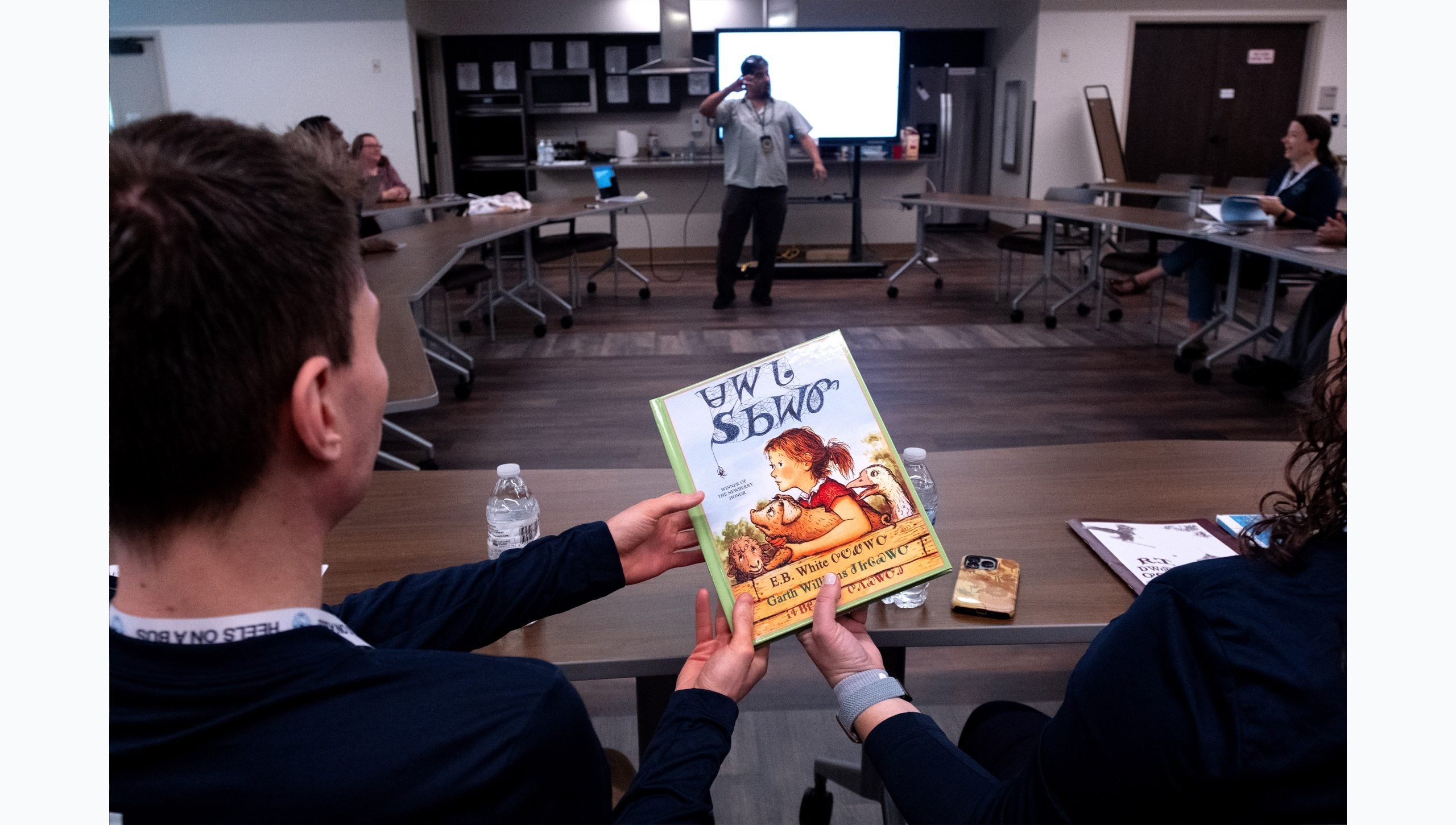 Bus Tour attendees passing around a Cherokee book.