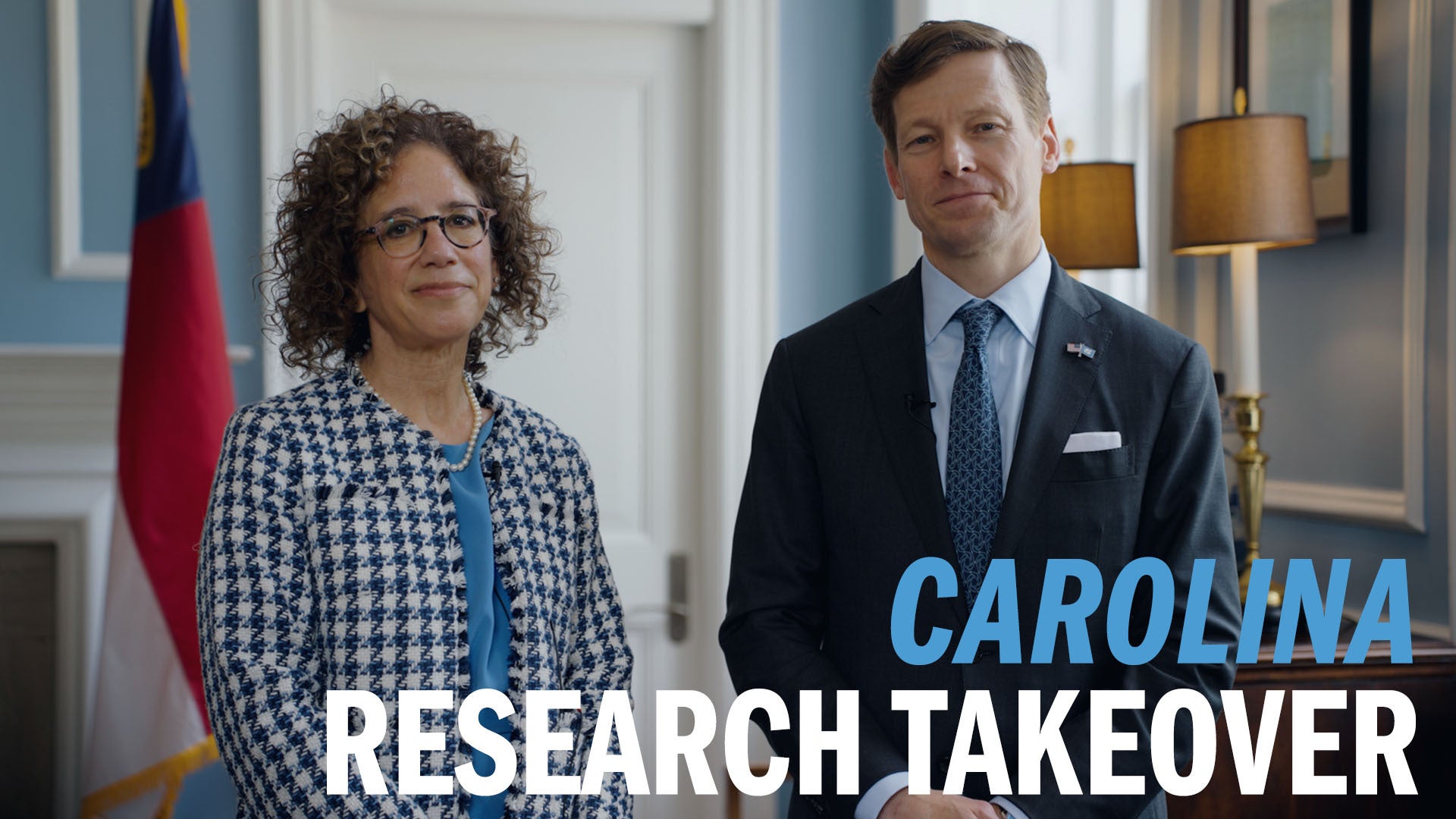 Penny Gordon-Larsen and Lee H. Roberts posing for photo in the chancellor's office in South Building on the campus of UNC-Chapel Hill. Overlayed his graphical text reading 