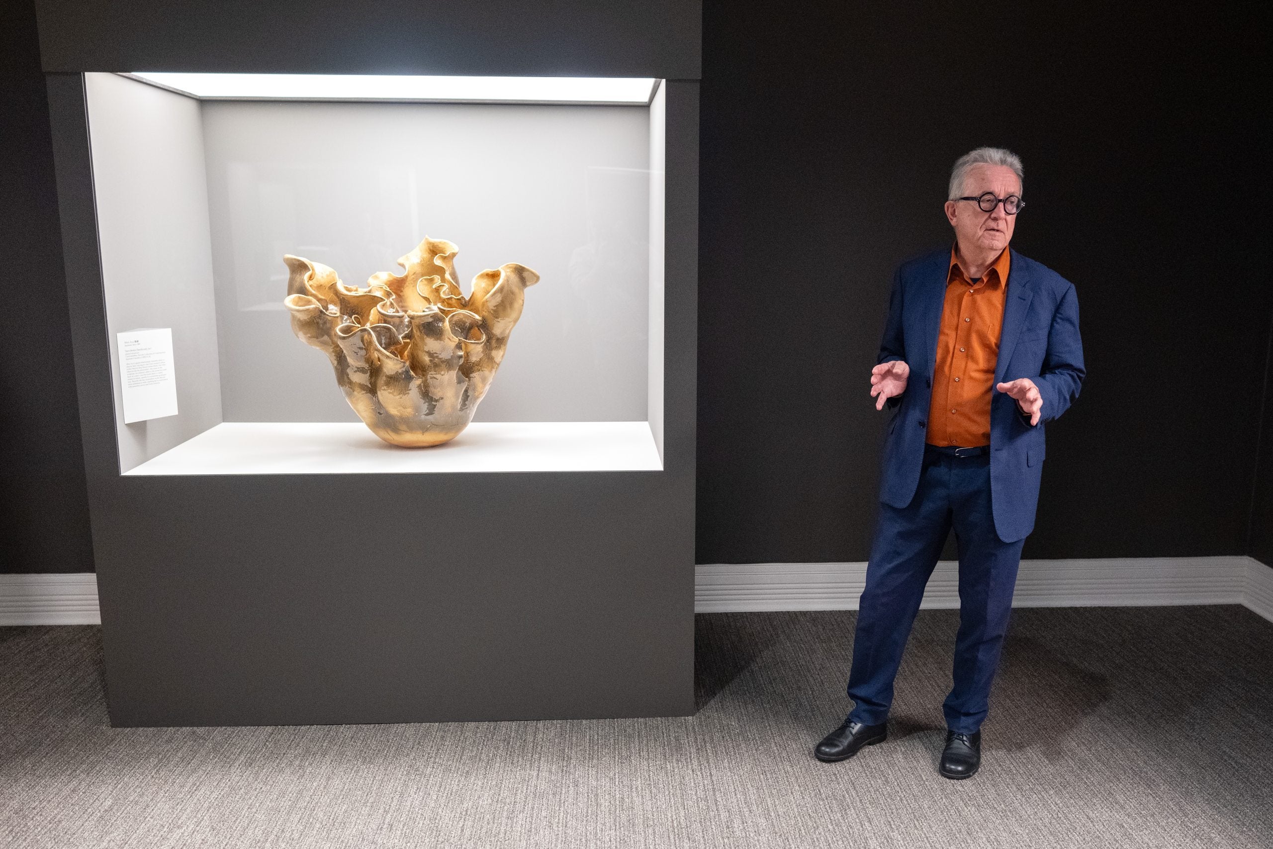 Joe Earle standing next to ceramic piece by Japanese artist Mori Aya.