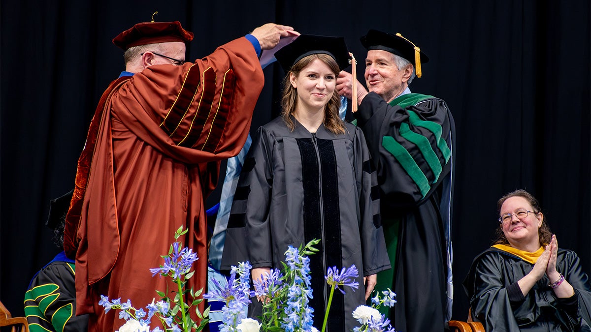 Provost Chris Clemens and Dr. Bert Peterson hooding Kim Enders at UNC-Chapel Hill's doctoral hooding ceremony.