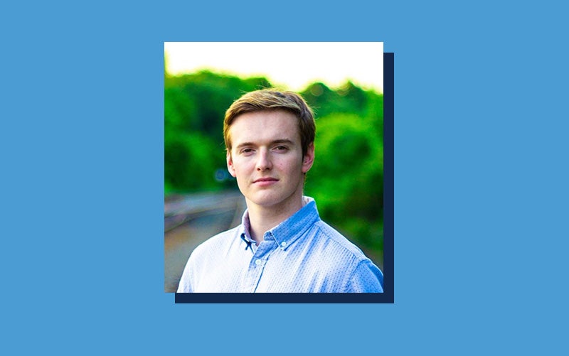 Portrait of Jeremy Fine atop a Carolina Blue background.