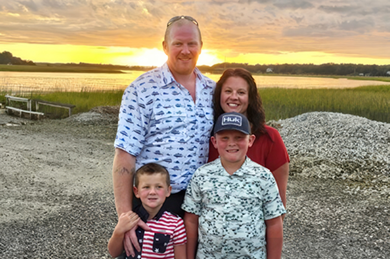 The Horney family poses for a photo with their sons at sunset.