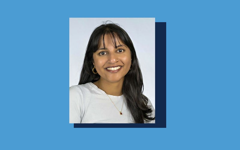 Portrait of Annie Oommen atop a Carolina blue background.