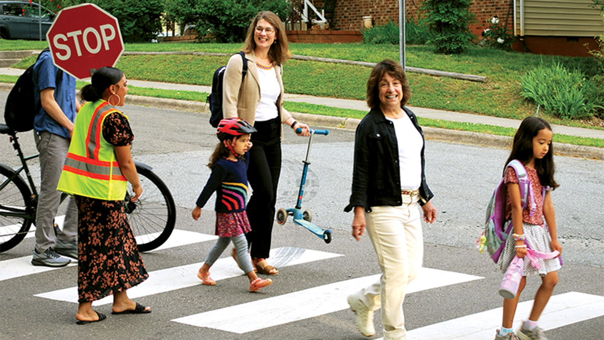 Group of people walking across street.