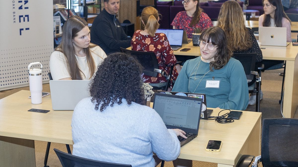 A group of students discussing their research at a shared table.