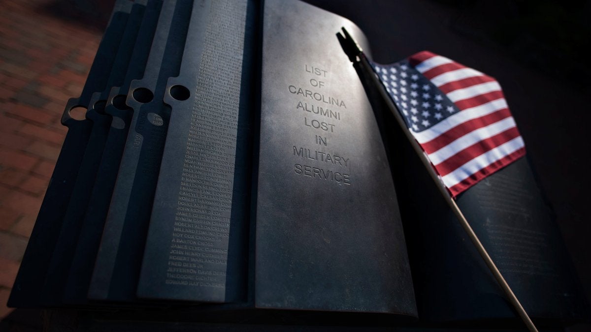 A flag leans against the memorial.