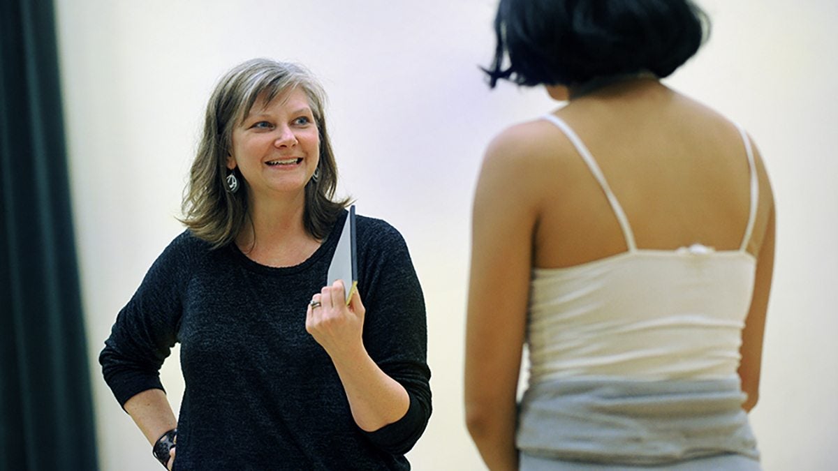 Two women speak with each other.