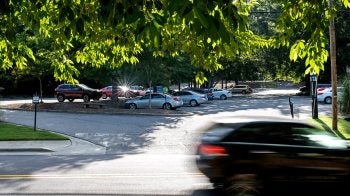 Car parking lot with car in foreground driving past.