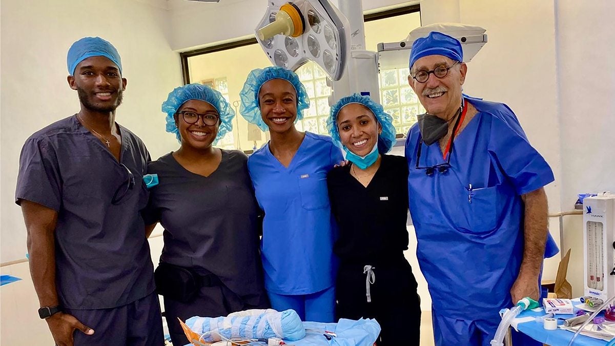 Five individuals posing wearing medical scrubs.