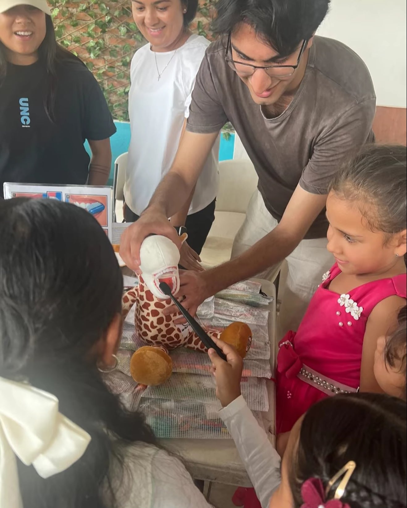 Man showing children how to properly use a toothbrush.